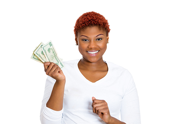 Woman smiling at the camera holding several 20 dollar bills in her hand