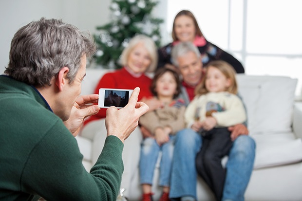 Father Photographing Family Through Smartphone