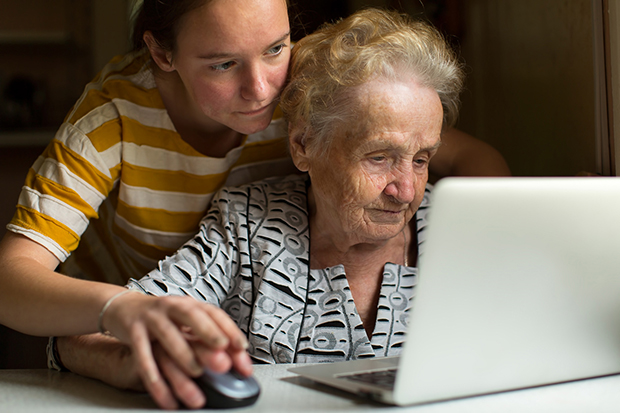 Young girl teaches her grandmother to work on the computer.