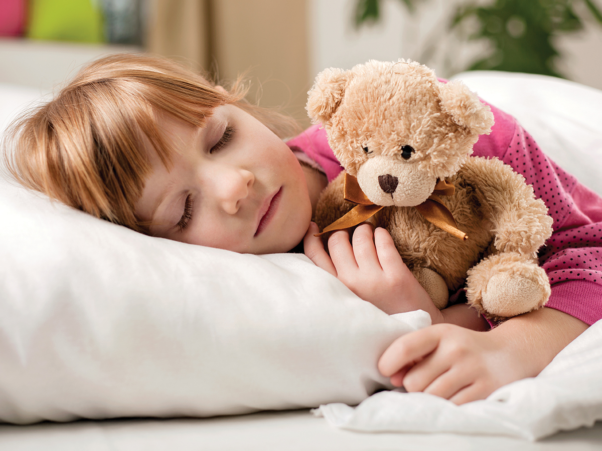 Child sleeping with her teddy bear