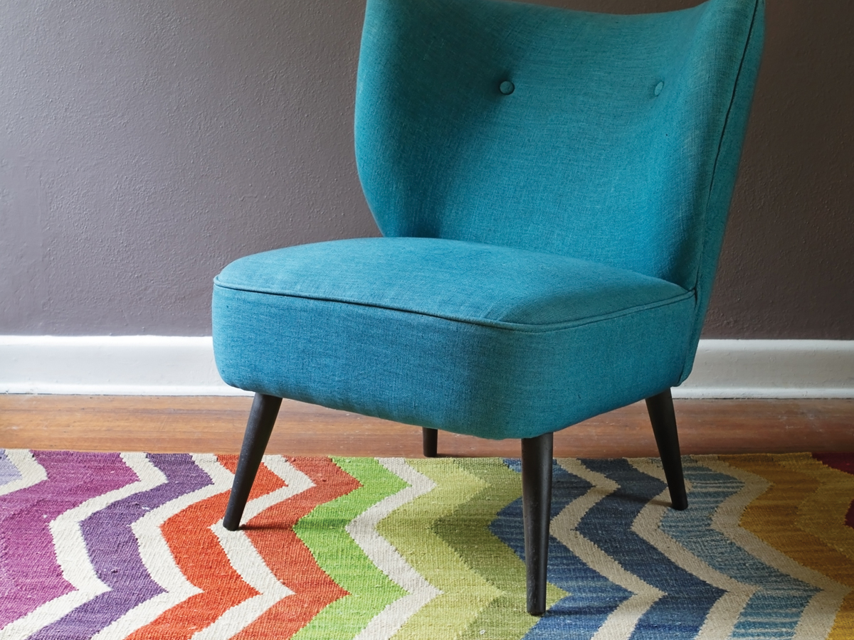 Teal chair on a striped rug