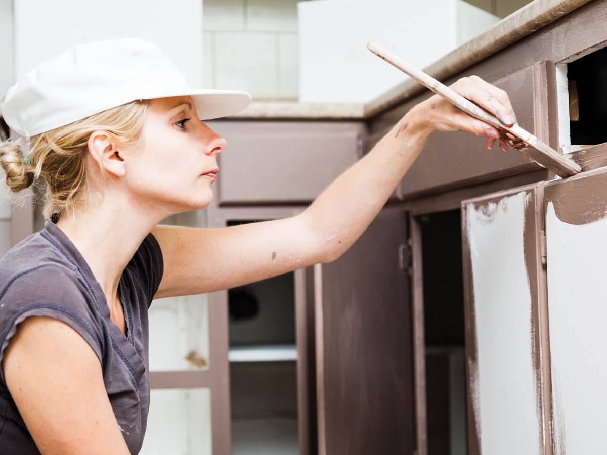 Woman painting kitchen cabinet