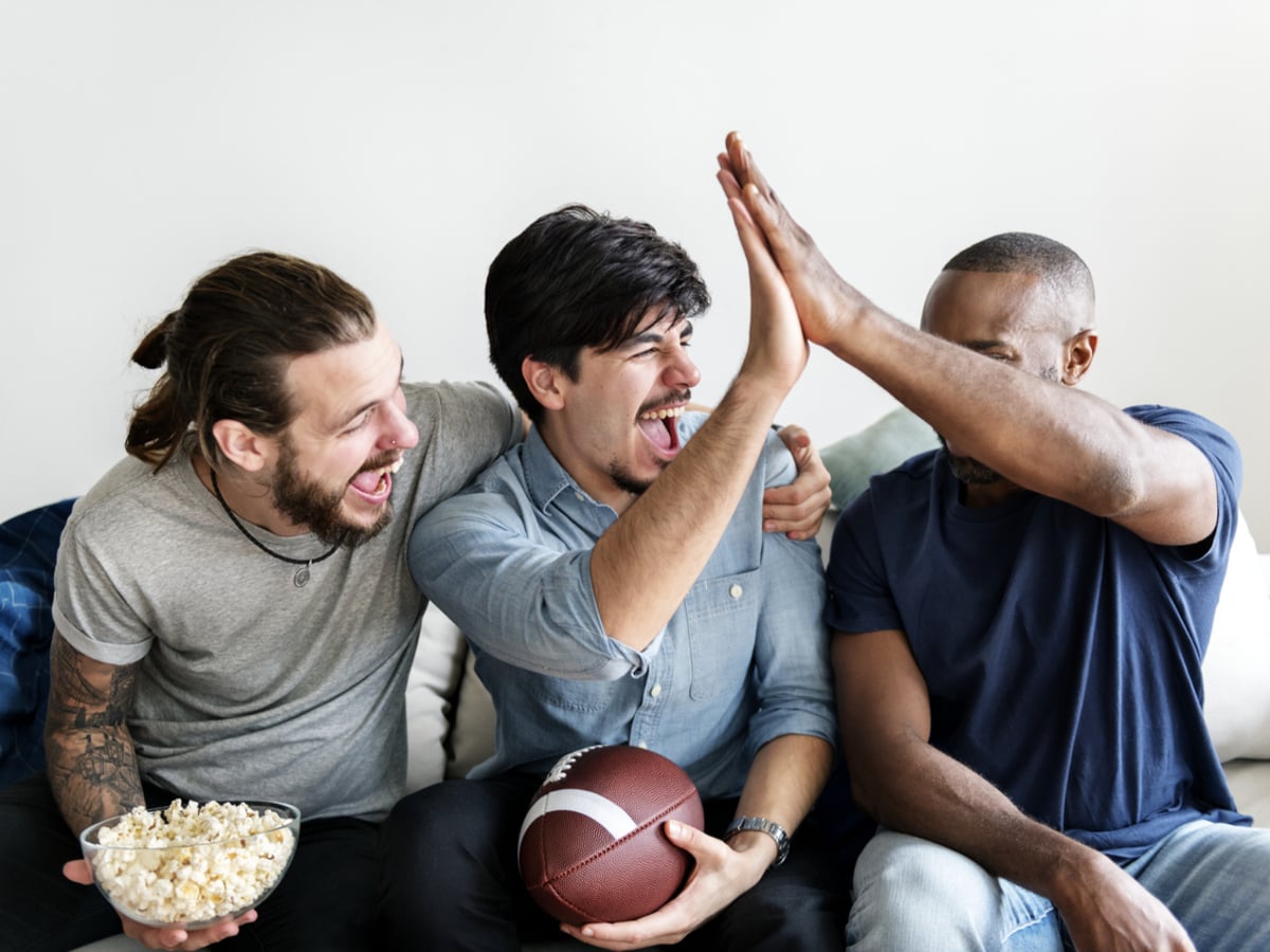 Three friends watching a football party