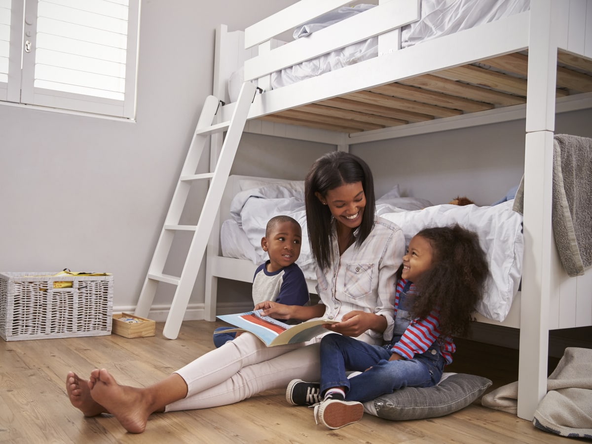 Mom with two kids leaning on bunk bed