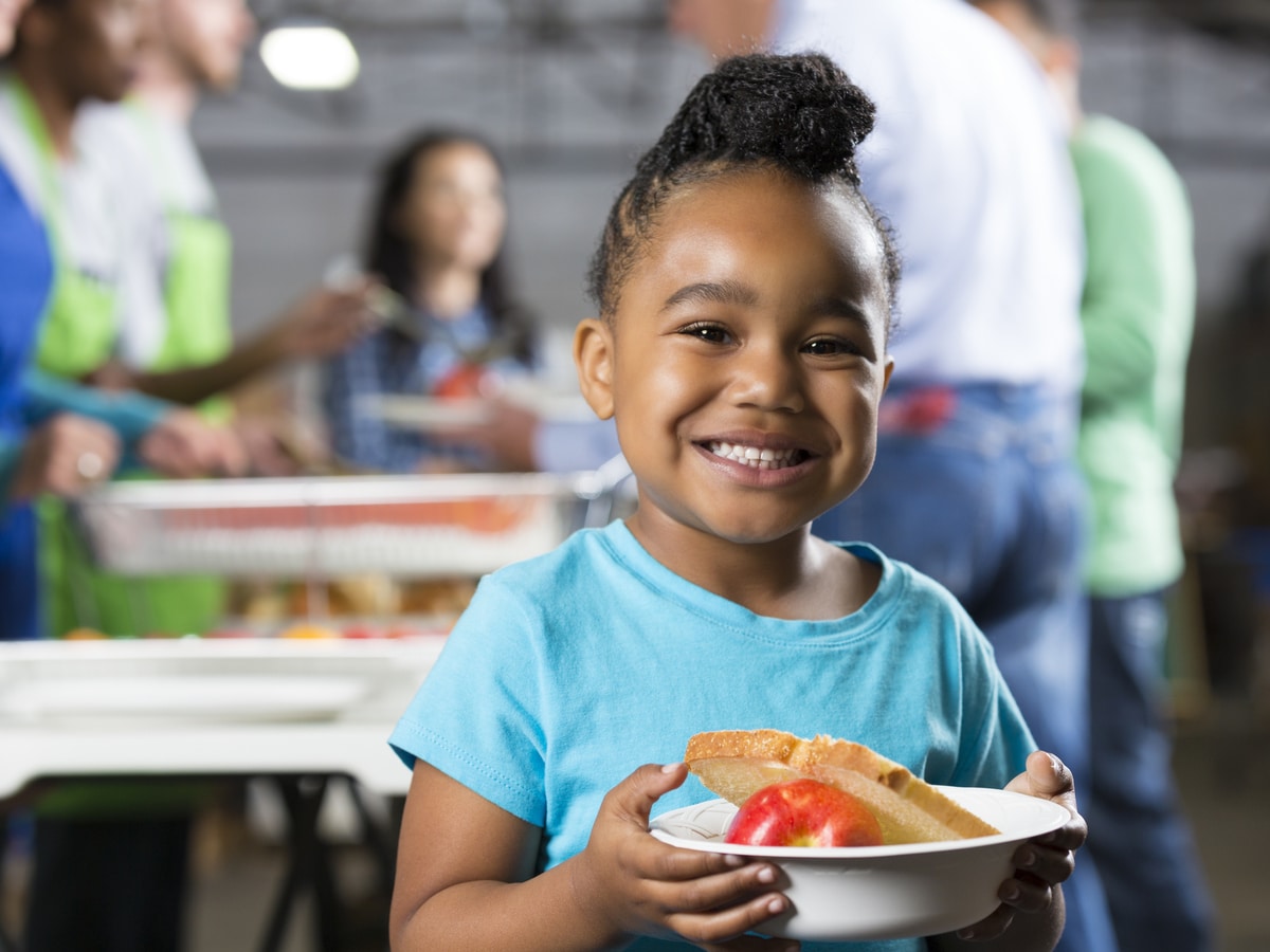 Girl holding a plate of food at a food bank