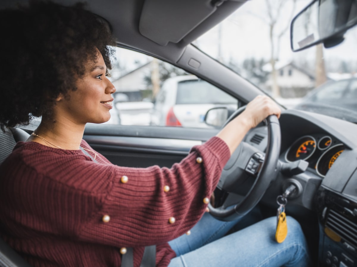 Woman in car holding steering wheel