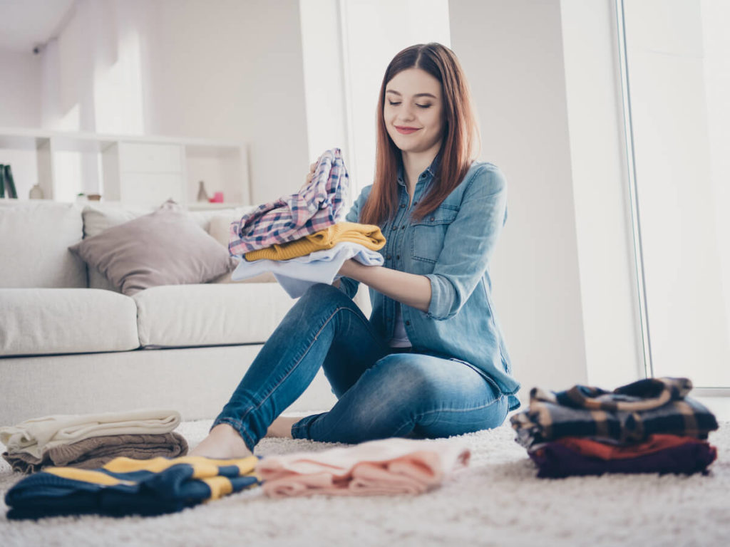 woman sitting on floor reorganizing her home