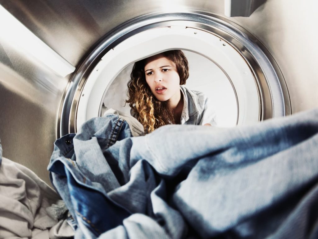 Inside view from dryer machine with woman looking into it
