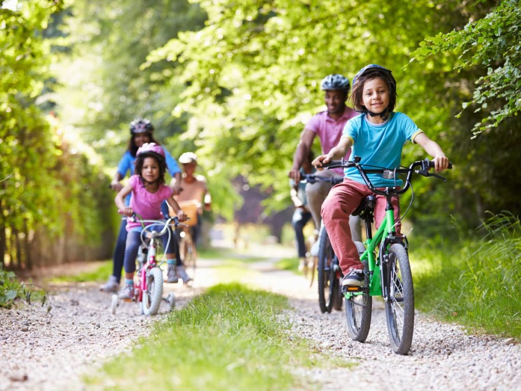 Family (parents, kids, grandparents) riding bikes on trail