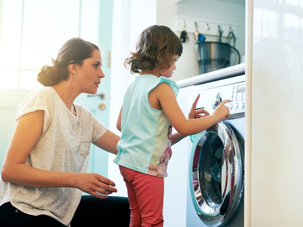 Woman and female child standing in front of dryer