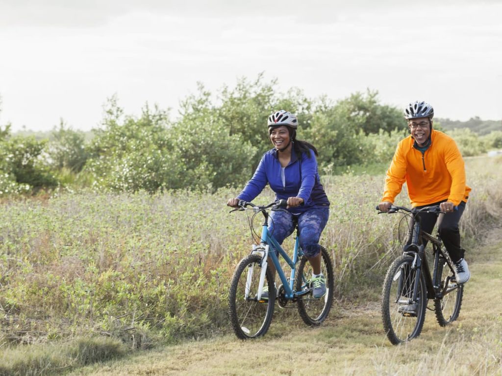 Two adults riding bikes through a trail