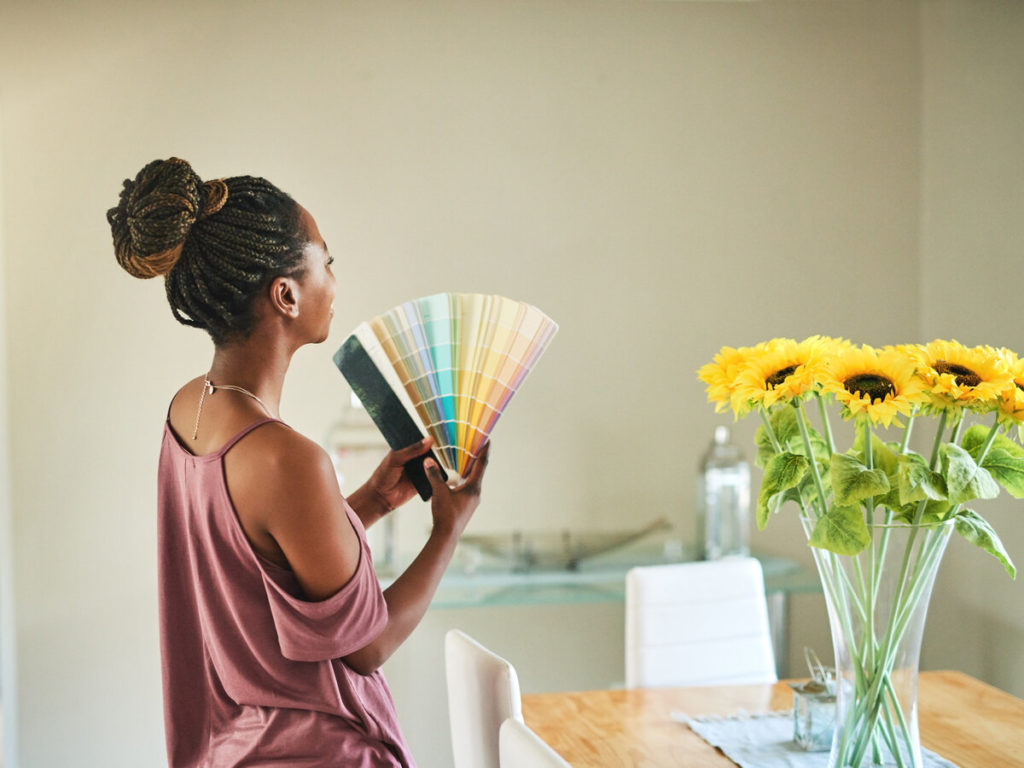 Shot of a young woman fanning out color swatches in dining room
