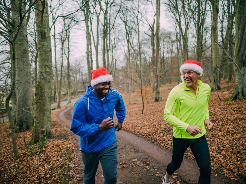 Two Joggers Up the Trails in the Forest at Christmas