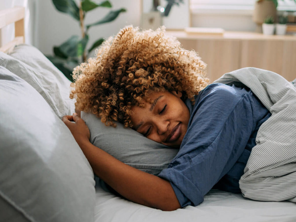 A woman is sleeping soundly in a plush, comfortable bed.