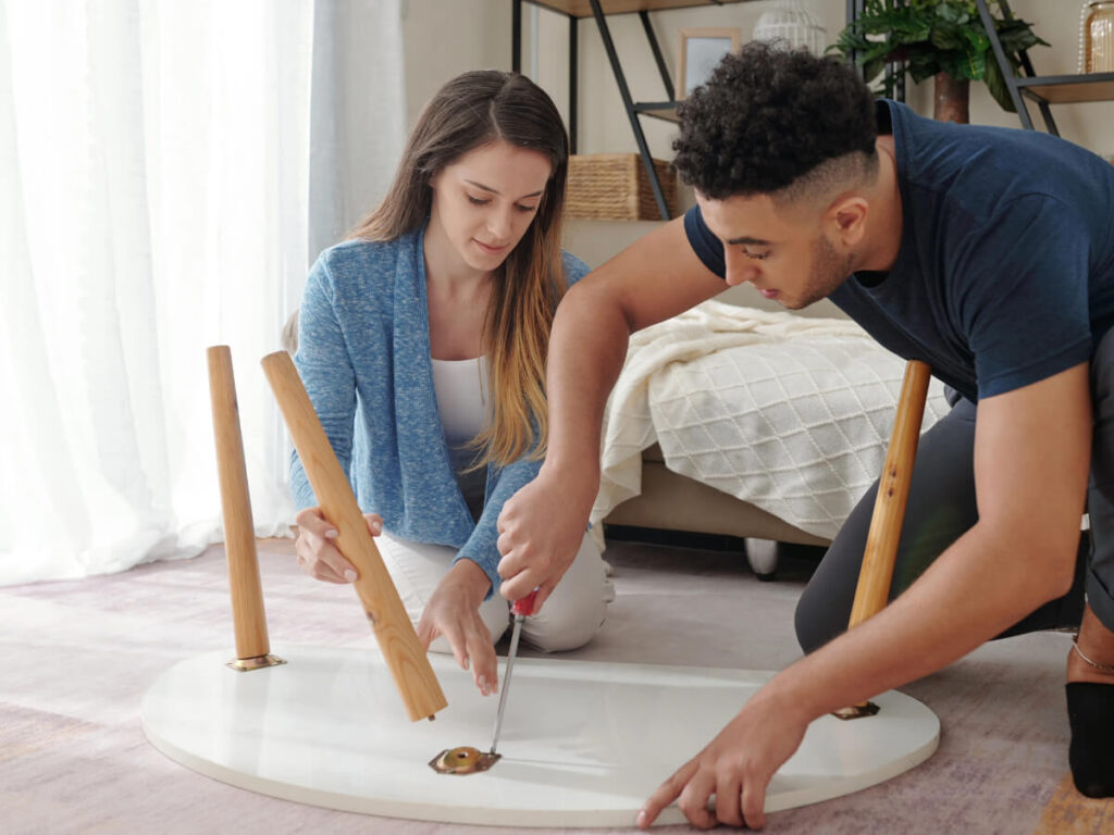 Couple fixing broken table leg