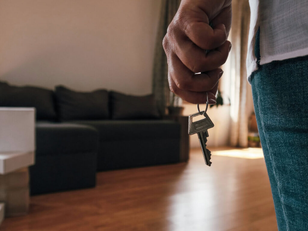 Back side view of a man in a home with a key in hand.