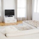 <b>Natural Light</b><br>
Let in as much natural light as possible to your living space. Ditch heavy curtains and valences. Choose unembellished window treatments in a light, neutral shade instead. Or go with simple blinds for when you need privacy and leave your windows uncovered when you don’t. White sectional in front of TV