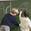 <b>Chalkboard Paint</b><br> Kids seem to have an instinctive need to draw on walls. Lucky for you, chalkboard paint has become more popular (and easier to find) in recent years, and it’s a quick way to personalize a plain room. Painting a whole wall and handing over a big box of chalk will inspire your child’s imagination—and perhaps even get him to do his homework. Two kids drawing on a chalkboard