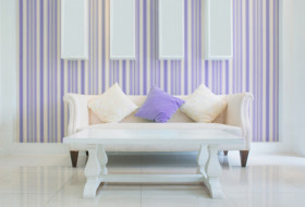 Purple striped wallpaper with cream couch