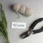 Simply write or print names onto paper and cut them into a neat shape. To make each place card extra special, punch a hole in each card and tie a little greenery (we used sprigs of rosemary) to each with string or twine.