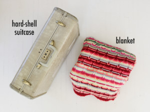 Start with a vintage hard-shell suitcase and a comfy blanket.