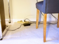 Computer and other electronic cords create a mess under the desk.