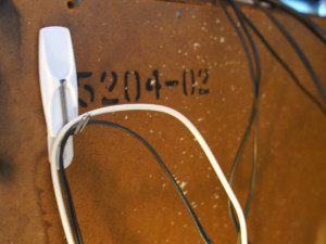 Hide cords from the TV using a stick-on hook placed on the back of the TV stand.