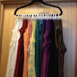 Tank tops hanging neatly on the same hanger.