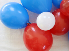 Tie two balloons together and knot them through the monofilament strand.