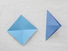 Fold paper in half diagonally (into a triangle shape), and in half again, then unfold.