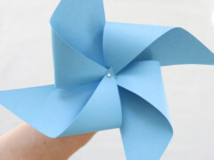 Overlap the pinwheel corners that have holes, and press the sewing pin through the overlapped corners and then through the center hole.