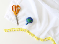 Cut the pom pom trim to the length of the curtain.