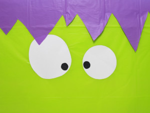 Use tape to secure the eyes to the center of the front of the tablecloth.