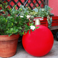 Giant red ornament next to plant