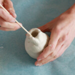 Work up the top of the vase to create the lip. Once shaped, slowly open the top by inserting a skewer and then your finger into the center.