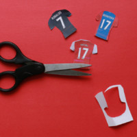 Cut-outs of paper jerseys with scissors