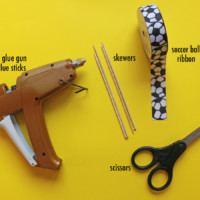 hot glue gun, scissors, soccer ball ribbon, and skewers
