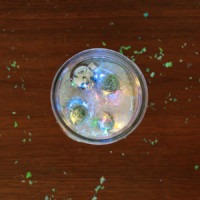Top view miniature christmas trees and string lights in a mason jar