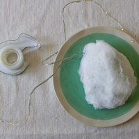 Clear tape and a cotton ball on a plate with string lights coming out