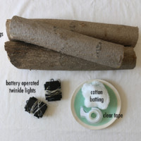 3 logs, 2 battery powered string lights, tape and a cotton ball with labels