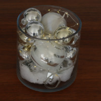 Christmas ornaments and string lights in a round vase